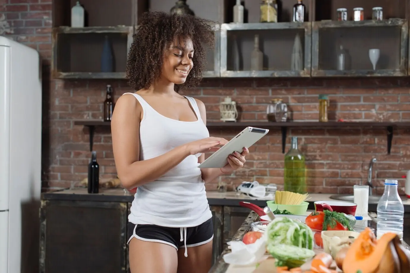 Eine Frau kocht mit einem Tablet.